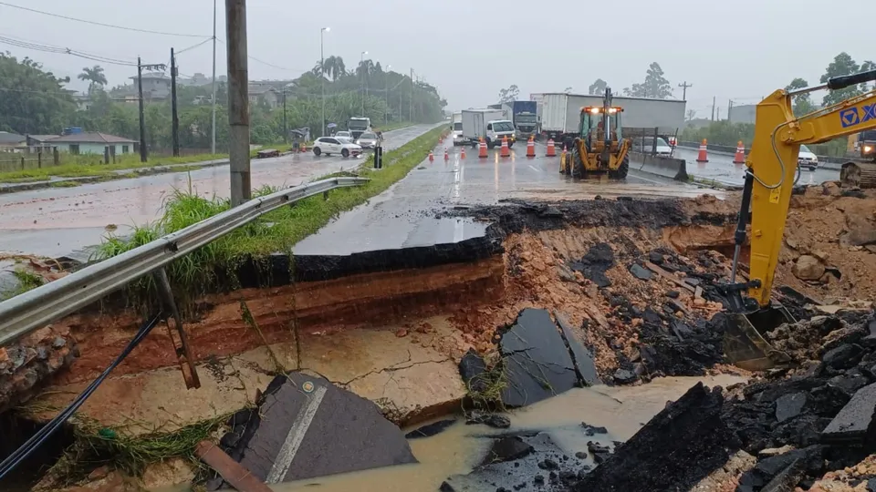 Após fortes chuvas na região, uma cratera se abriu na BR-101, em Biguaçu, bloqueando totalmente a rodovia e gerando transtornos.
